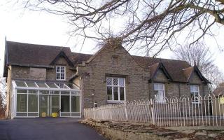 Old stone school house converted into community centre with glass foyer