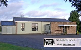 Light green and brick village hall with Flicks in the Sticks sign
