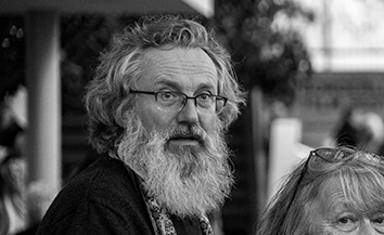 Black and white portrait of man with long white beard and glasses