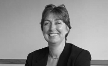 Woman with short hair and dark suit smiling
