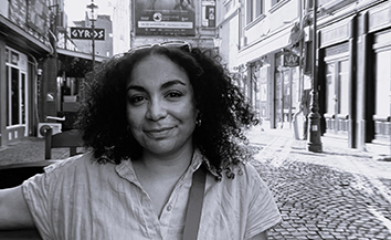 Young Black woman with shoulder-length hair, wearing white t-shirt in city street