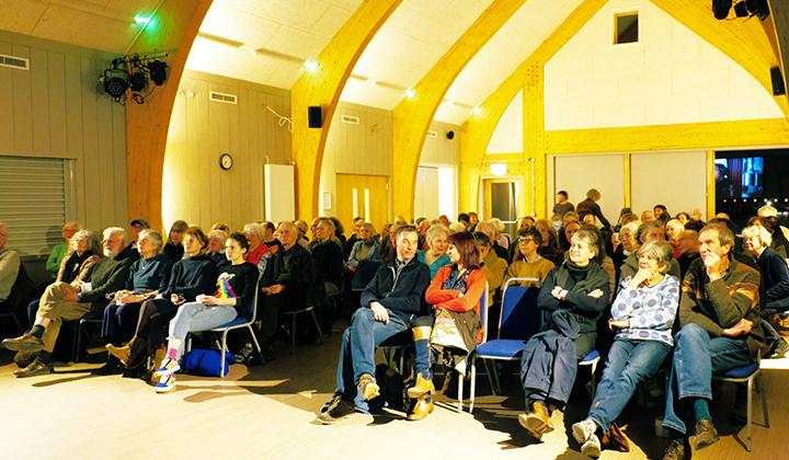 Spacious hall interior with people seated for a film